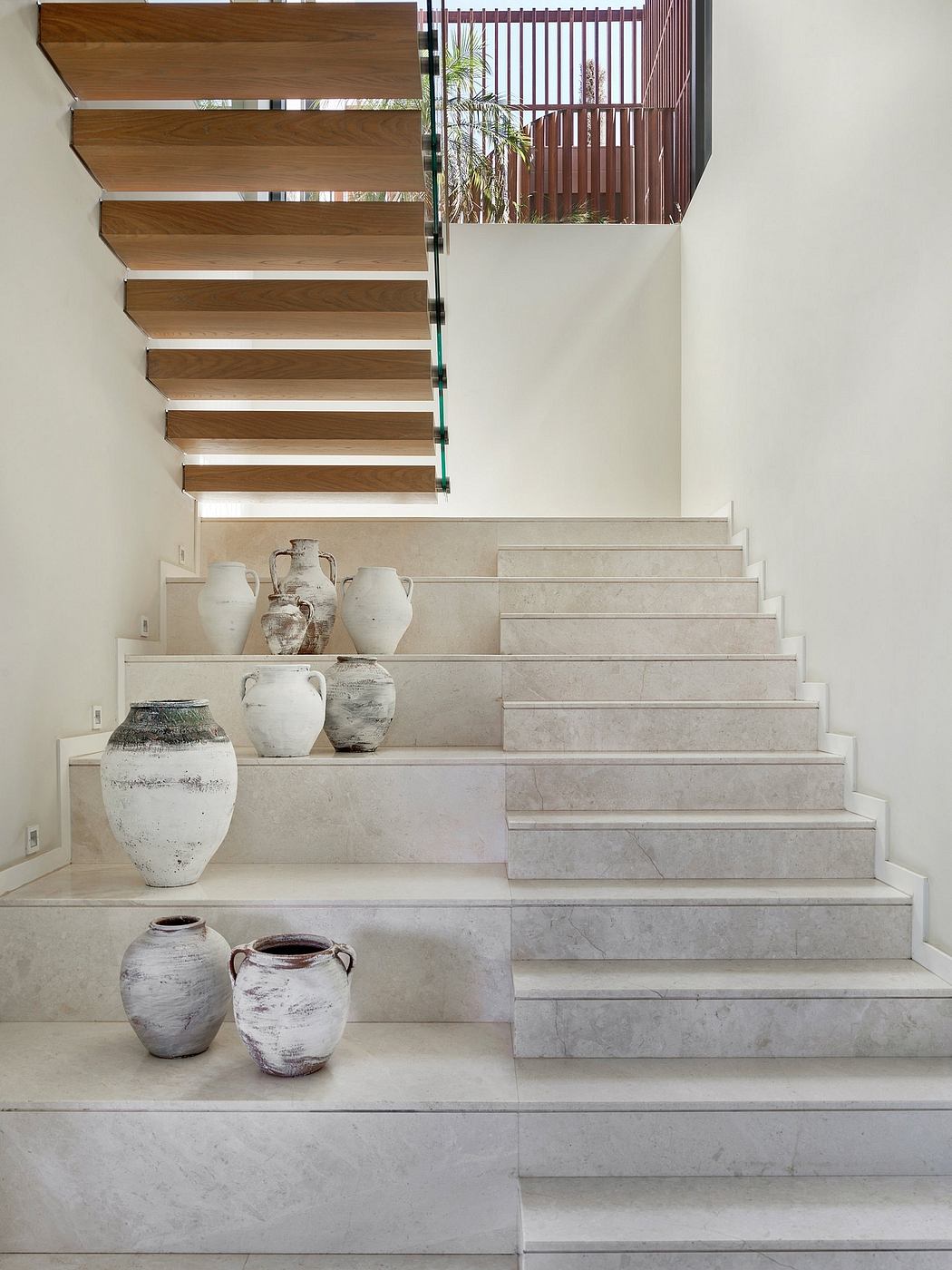 Striking wooden staircase with niche displaying antique pottery pieces.