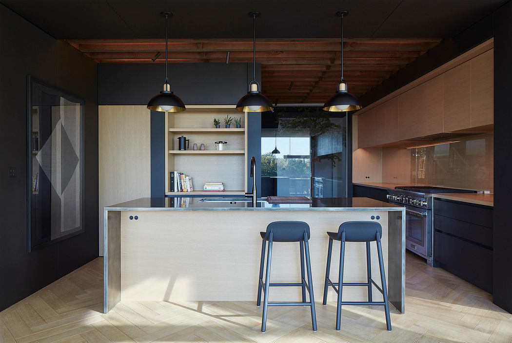 Modern kitchen with sleek wood, glass, and metal design elements. Pendant lights and a minimalist island with stools create a stylish space.