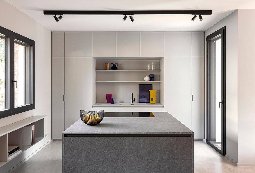 Modern kitchen with sleek gray cabinetry, concrete island countertop, and recessed lighting.