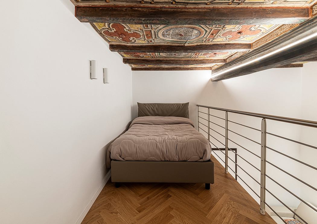 Ornate wooden ceiling beams and a modern minimalist bed in this eclectic room.
