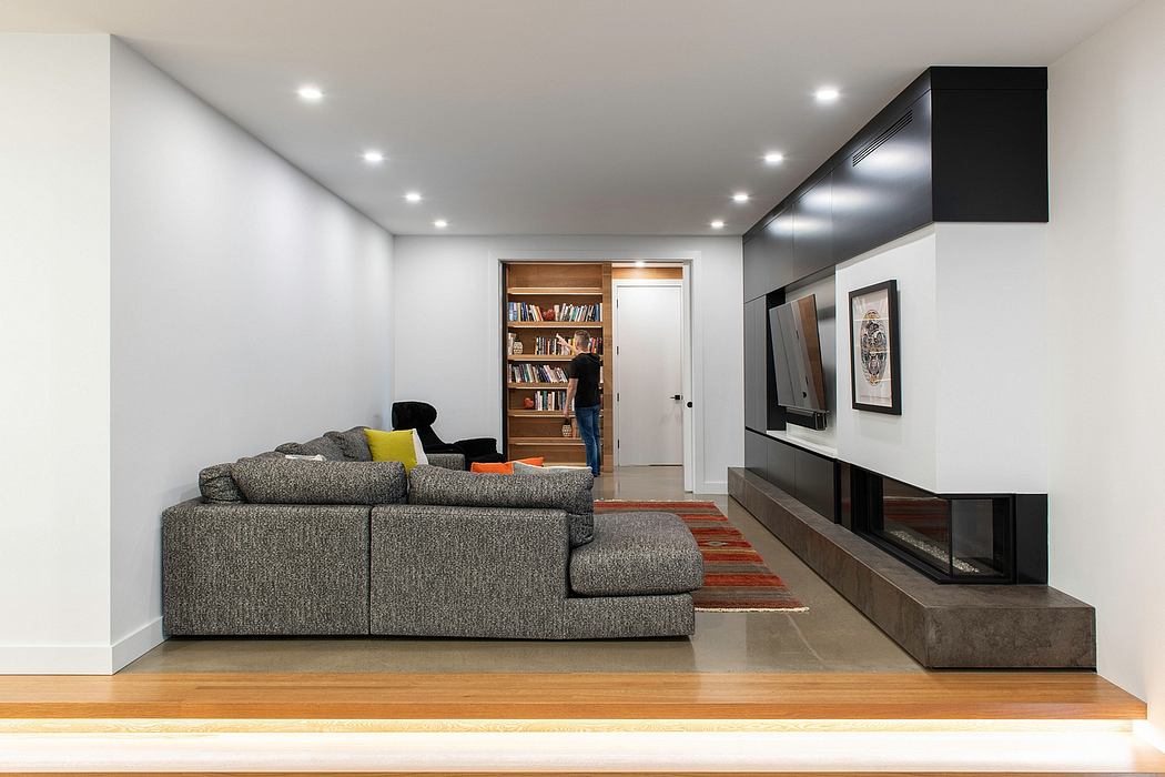 Minimalist living room with built-in fireplace, bookshelf, and modern furniture.