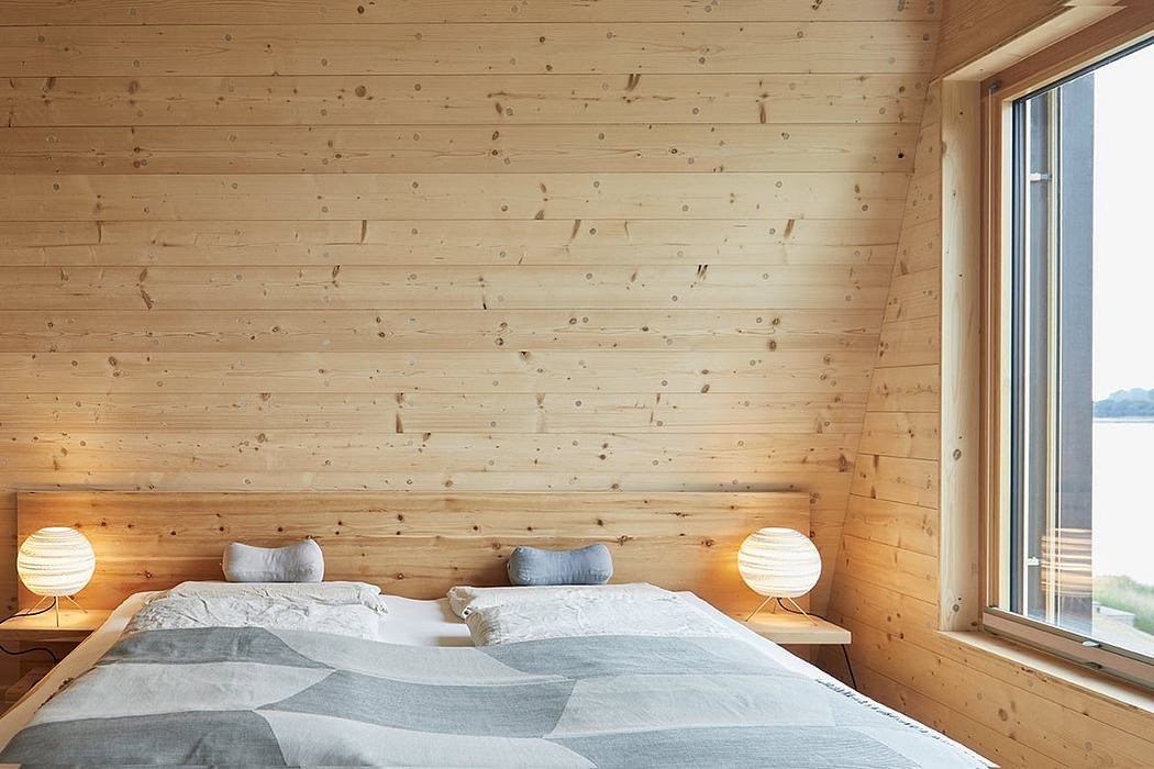 Cozy wooden bedroom with minimalist design, large window overlooking scenic view.