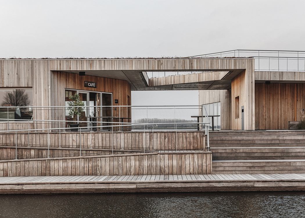 Wooden cafe building with a deck overlooking a body of water. Minimalist architectural design.