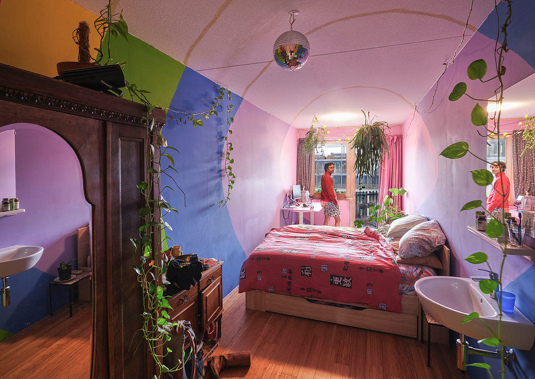 Colorful and cozy bedroom with vibrant walls, lush plants, and a disco ball hanging overhead.