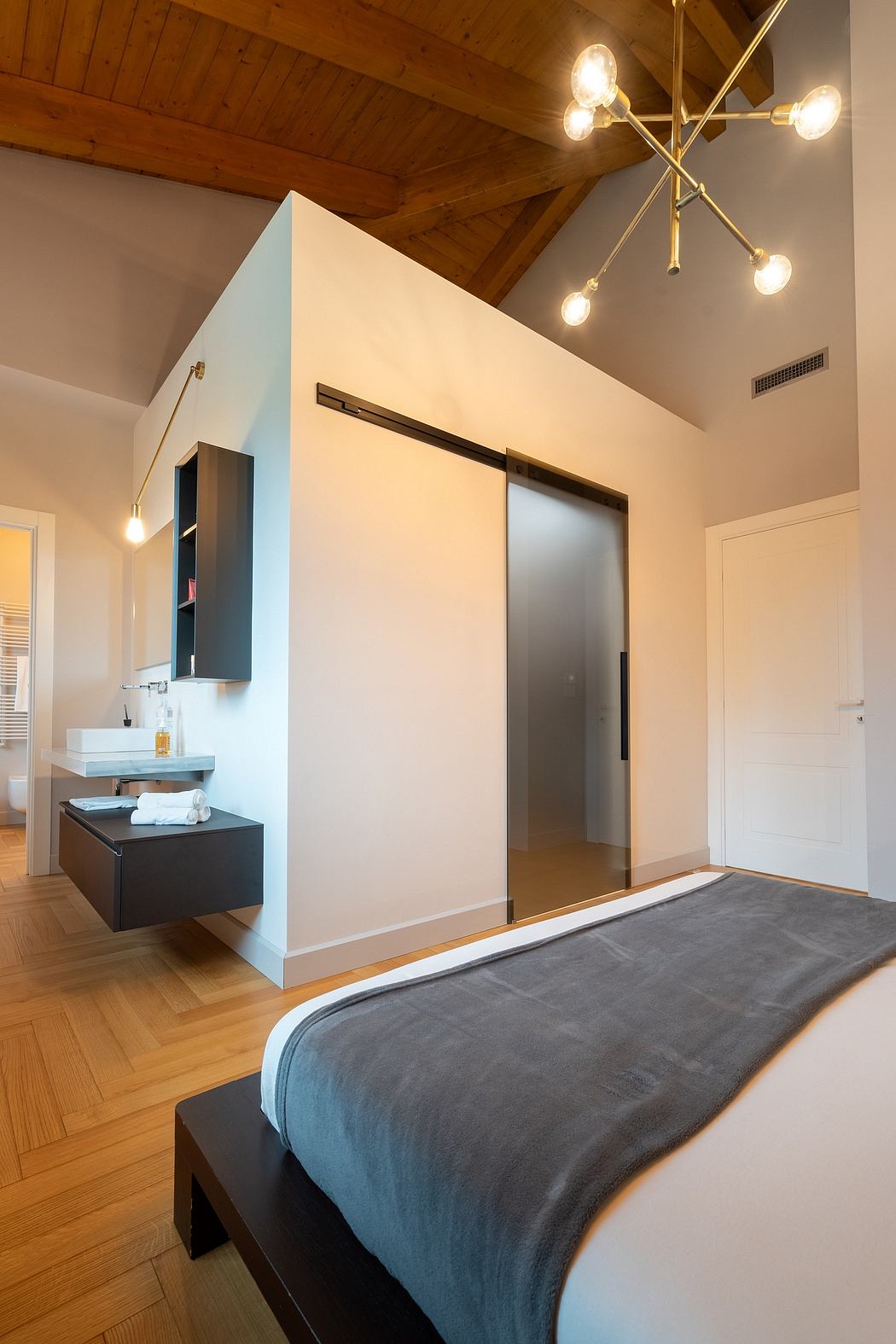Cozy bedroom with wooden ceiling, modern vanity, and sliding closet doors.