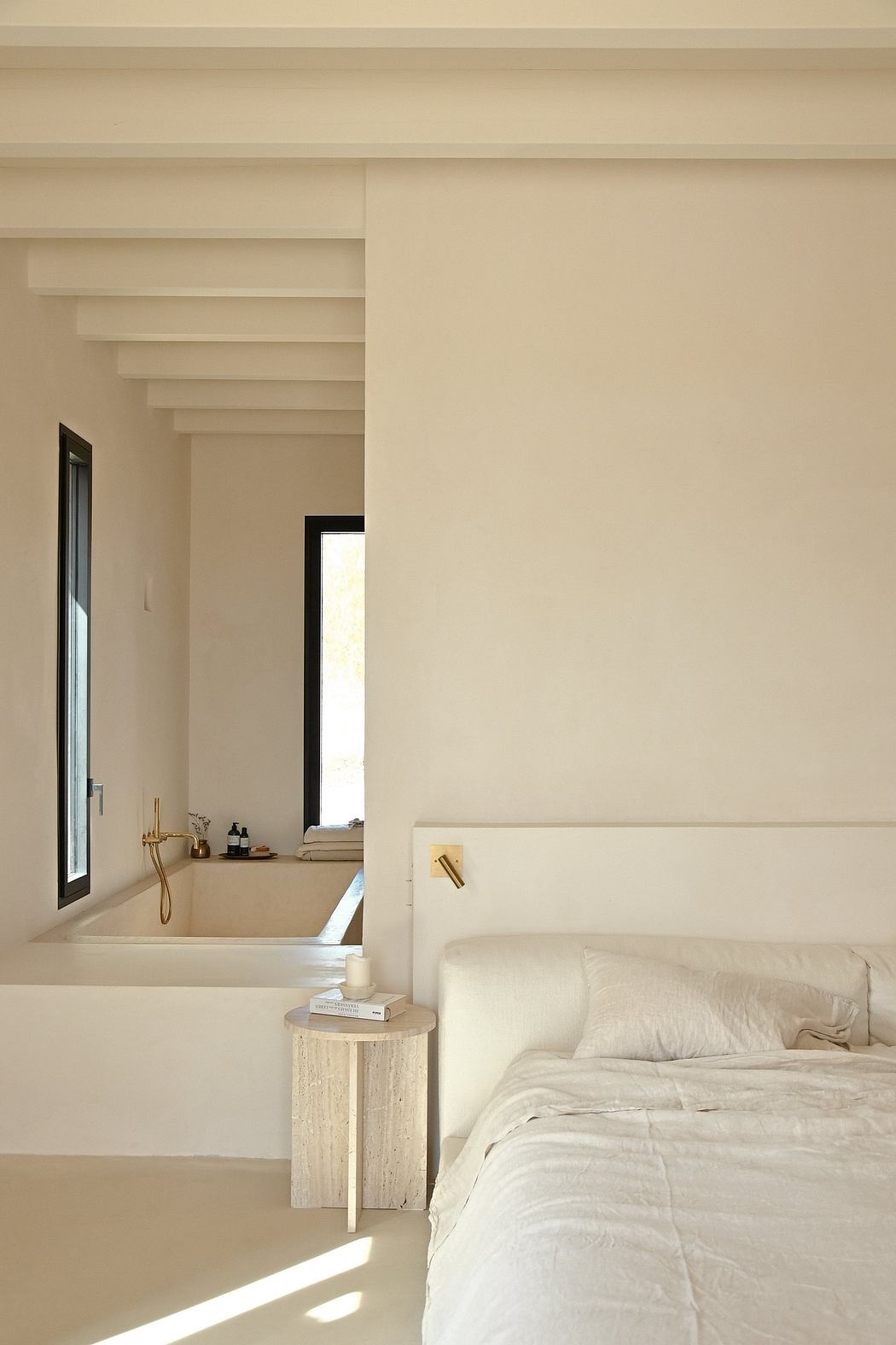 Minimalist bedroom with built-in shelves, bathtub, and neutral color palette.