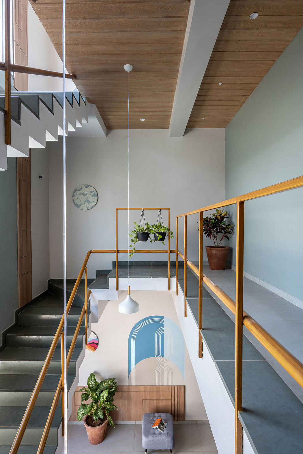 Sleek modern staircase, wooden ceiling, hanging plants, geometric decor, minimalist aesthetic.