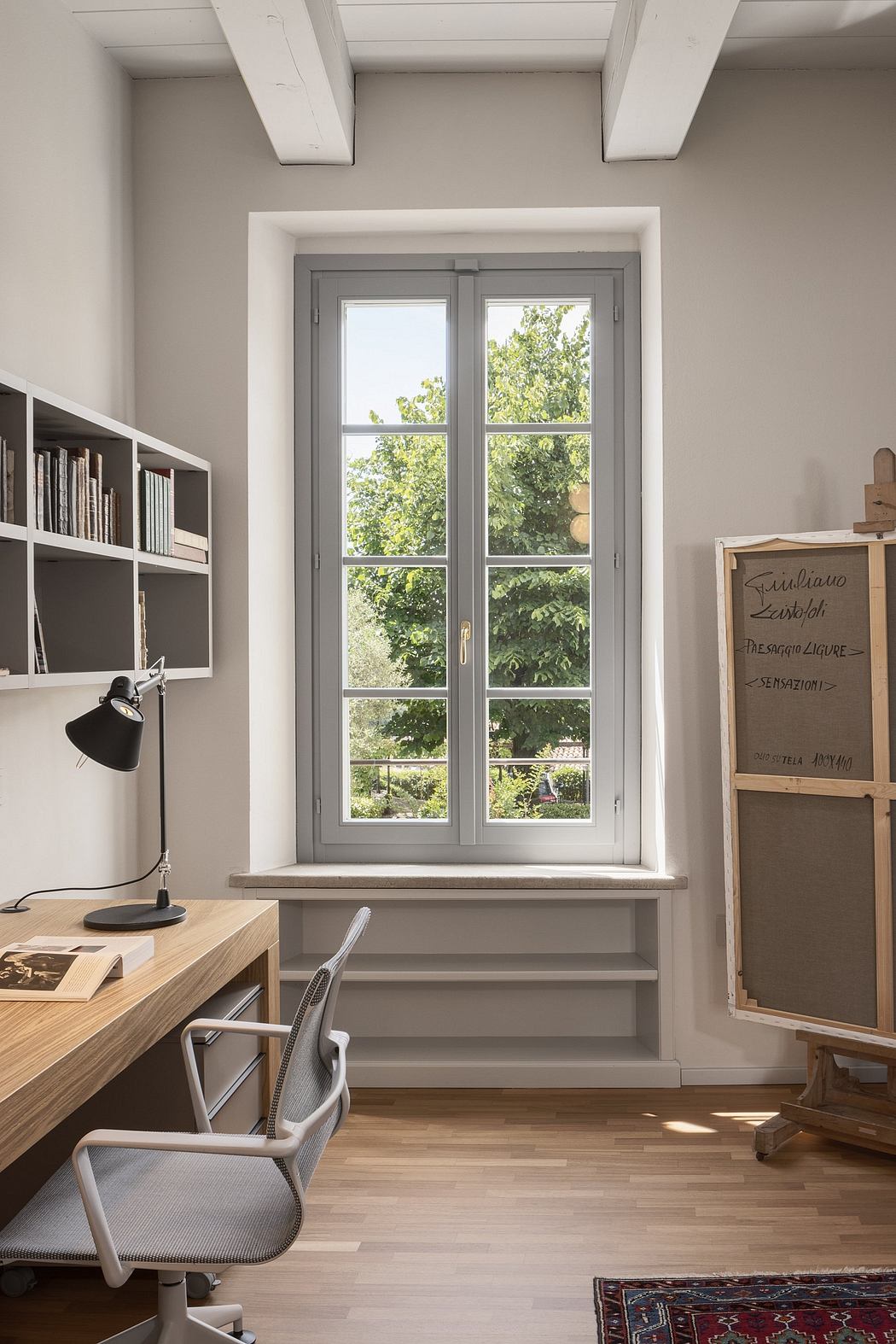 Cozy home office with large windows, exposed beams, and a mix of modern and rustic elements.