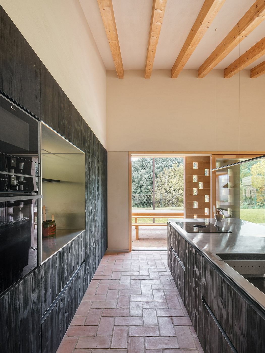 Spacious kitchen with sleek black cabinetry, exposed wood beams, and tile flooring.