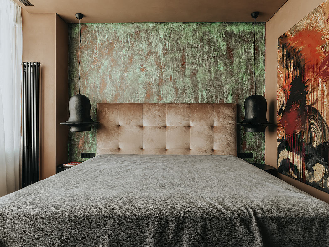 A cozy, modern bedroom with a plush beige headboard, textured green walls, and abstract art.