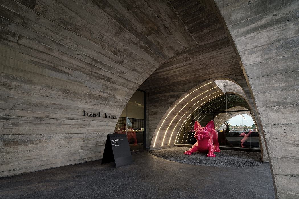 Dramatic archway with arched wood paneling and a bright pink sculptural feature.