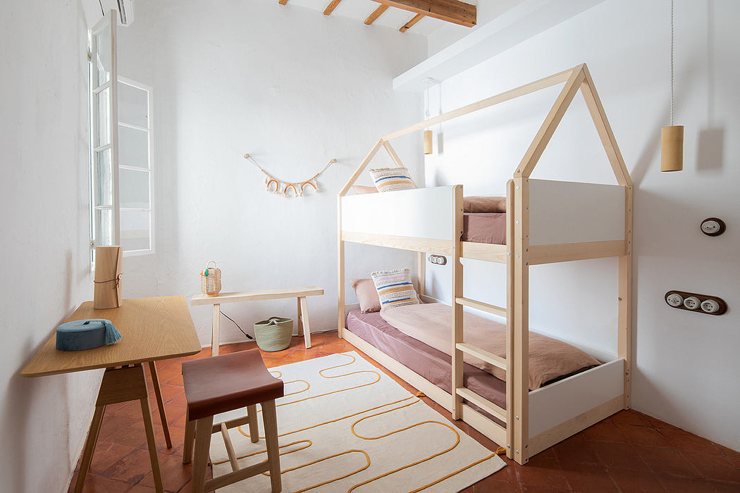 A cozy, modern children's bedroom with wooden bunk beds, desk, and colorful accents.
