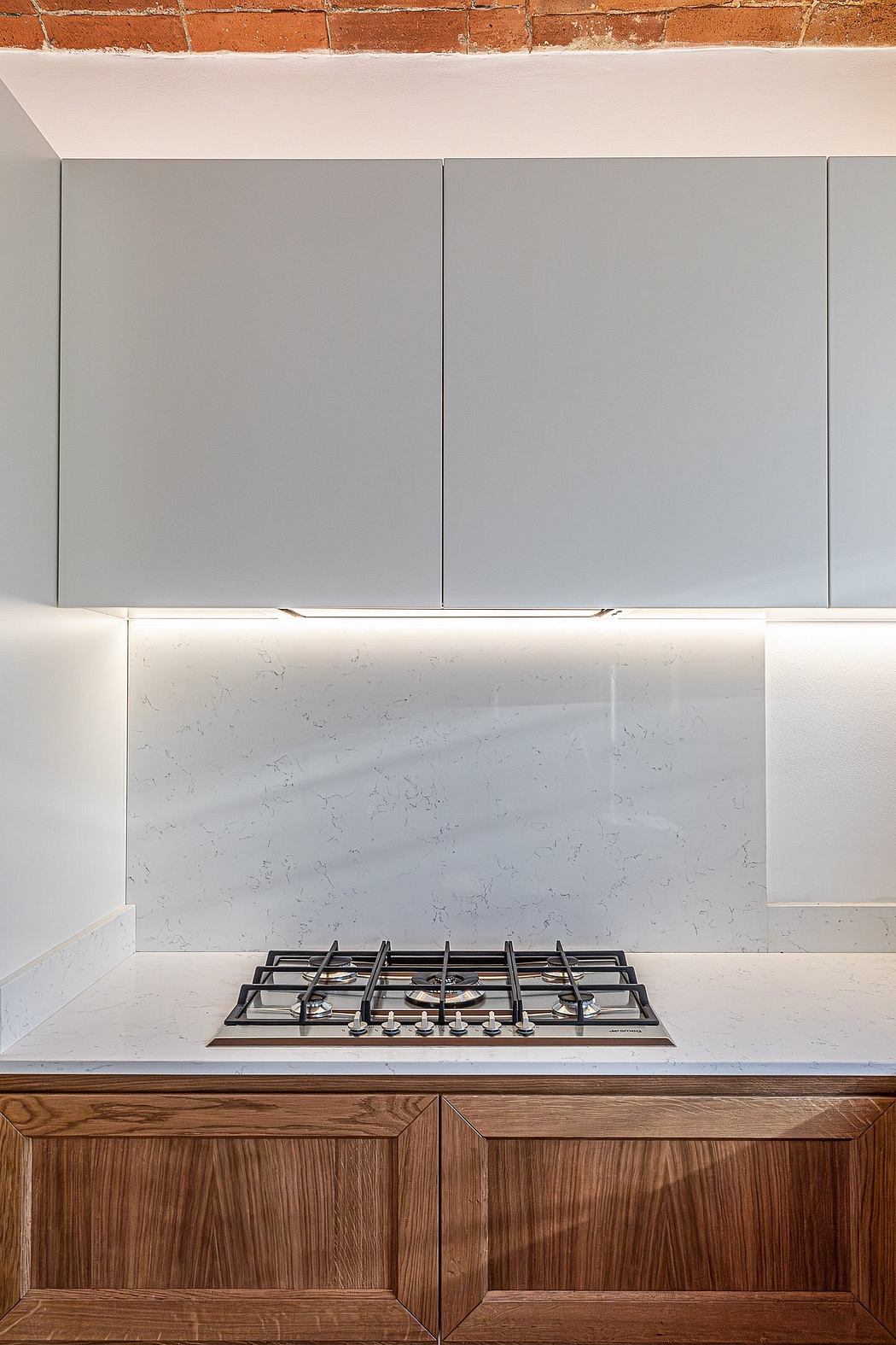 Modern kitchen with sleek gray cabinets, marble backsplash, and wooden base units.