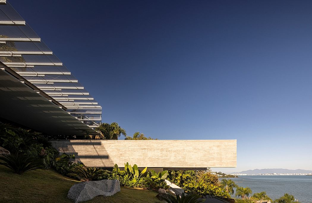 This modern, terraced building overlooks a scenic coastal landscape.