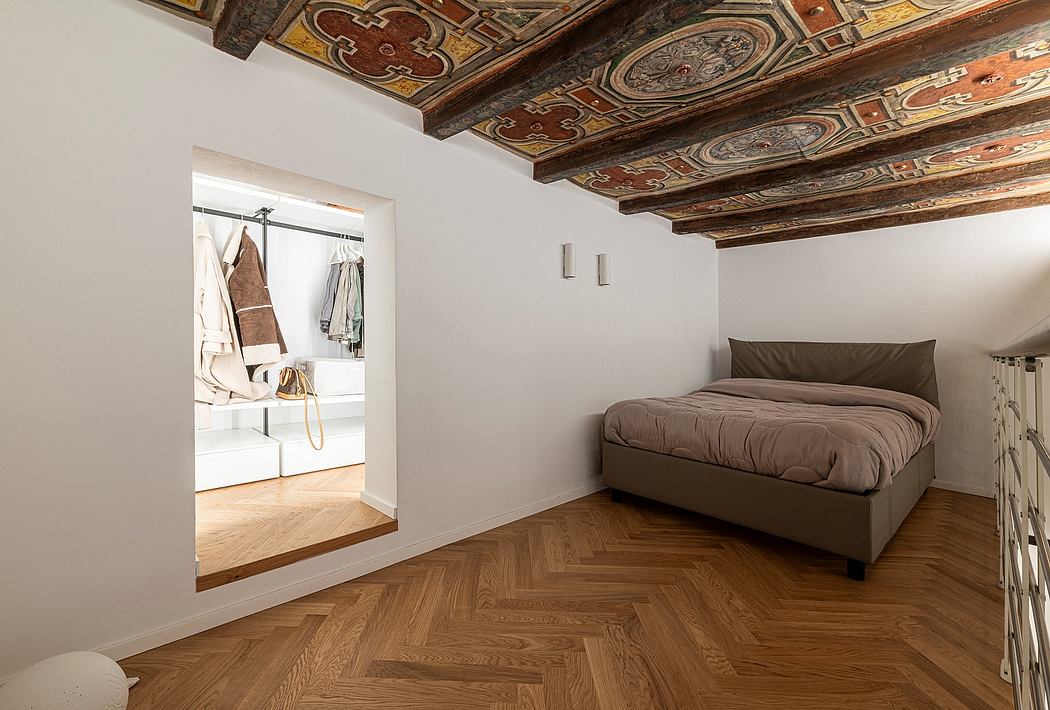 Ornate wood-paneled ceiling contrasts with modern minimalist bedroom furnishings.