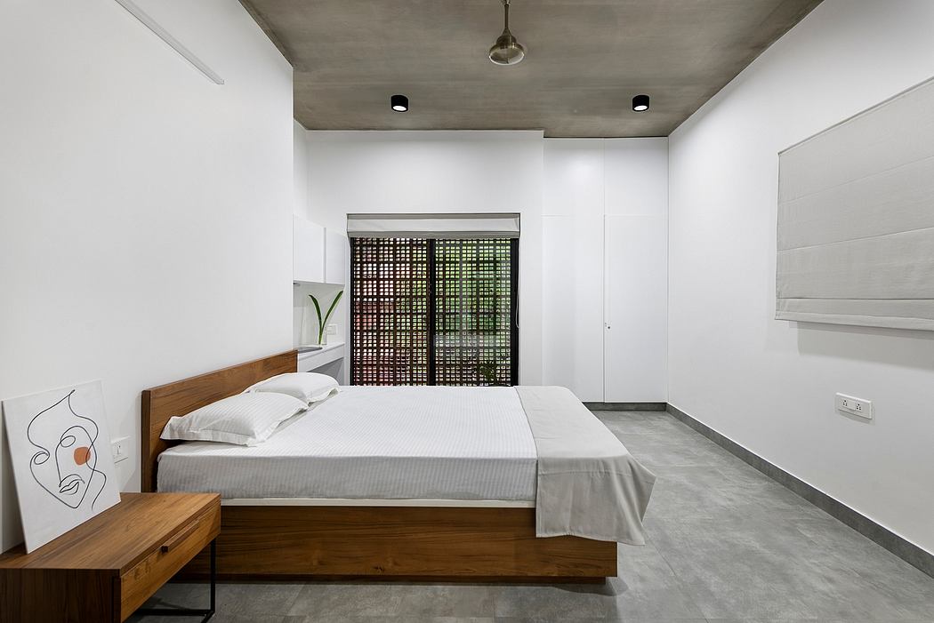 Minimalist bedroom with concrete ceiling, wooden bed frame, and patterned window screen.