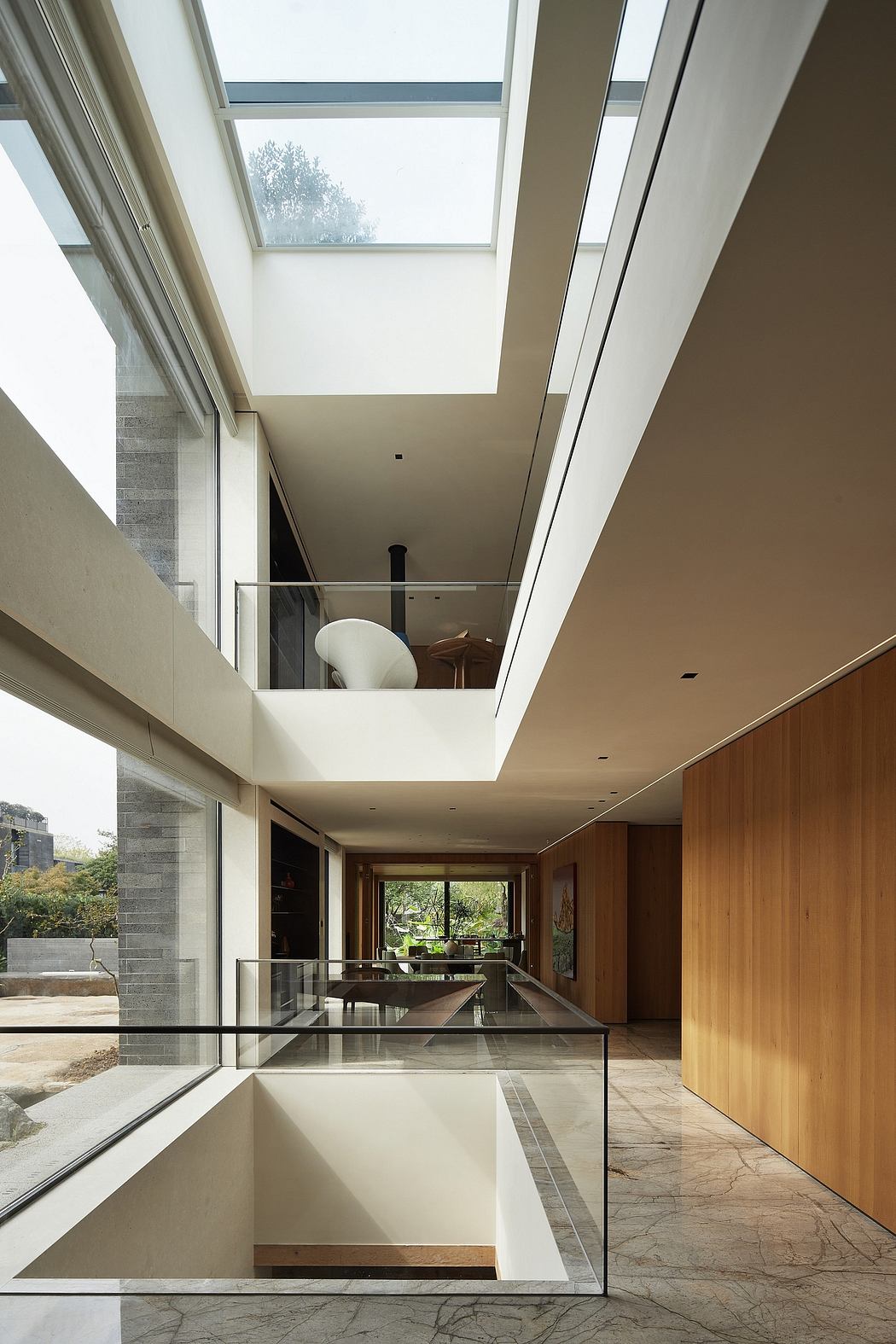 A modern, minimalist interior with floor-to-ceiling windows, sleek glass partitions, and clean lines.