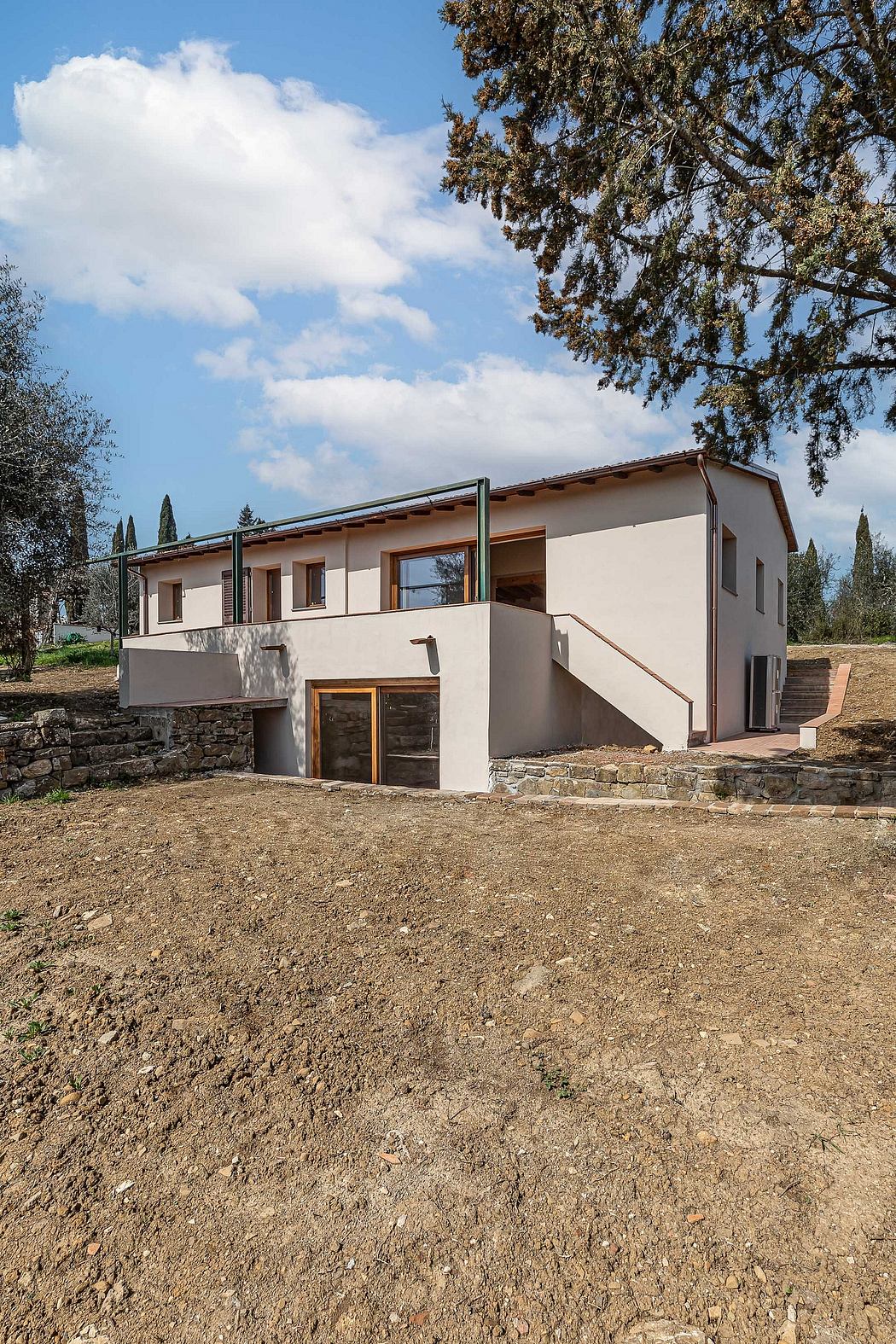 A modern, two-story home with a stone foundation, wood-framed exterior, and large windows.