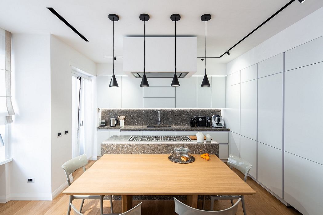 Minimalist kitchen with granite countertops, wooden dining table, and pendant lighting.