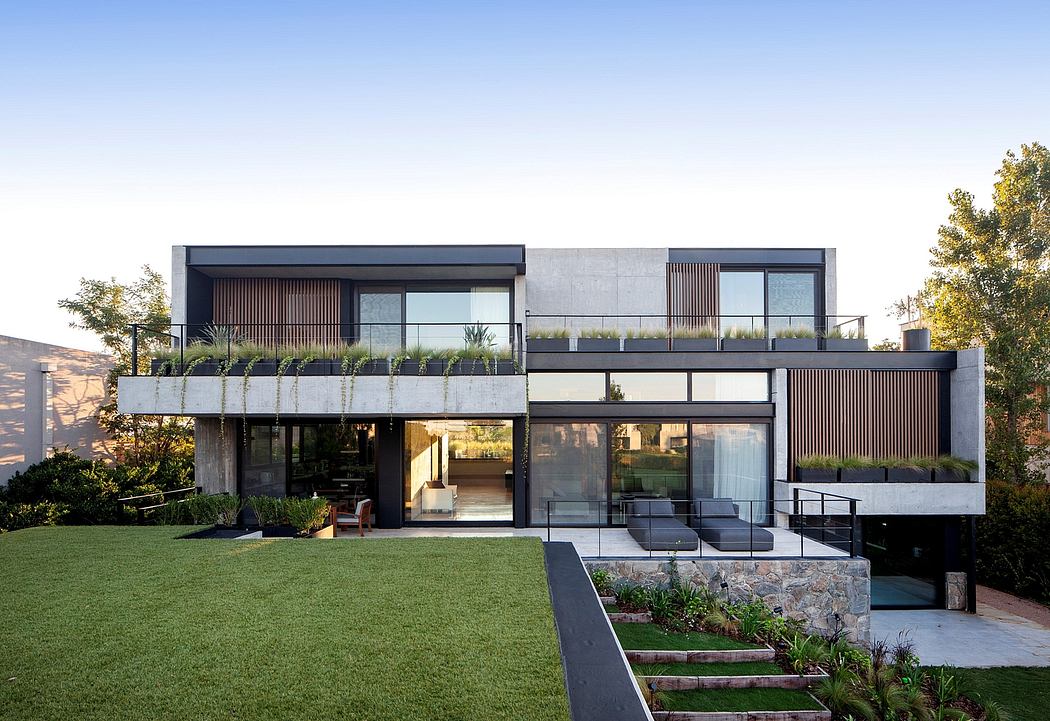 Sleek, modern house with concrete, wood, and glass elements, surrounded by landscaped yard.