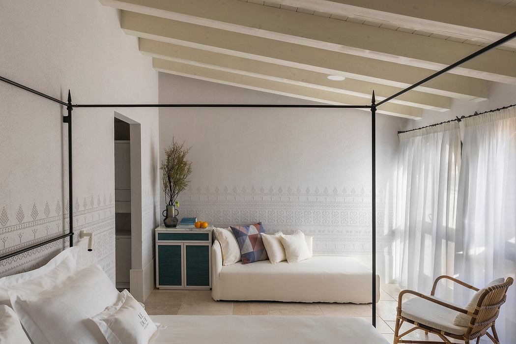 Cozy bedroom with beamed ceiling, patterned accent wall, and modern furnishings.