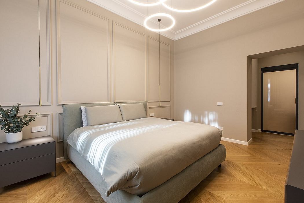 Elegant bedroom with modern lighting, wood flooring, and neutral-toned decor.