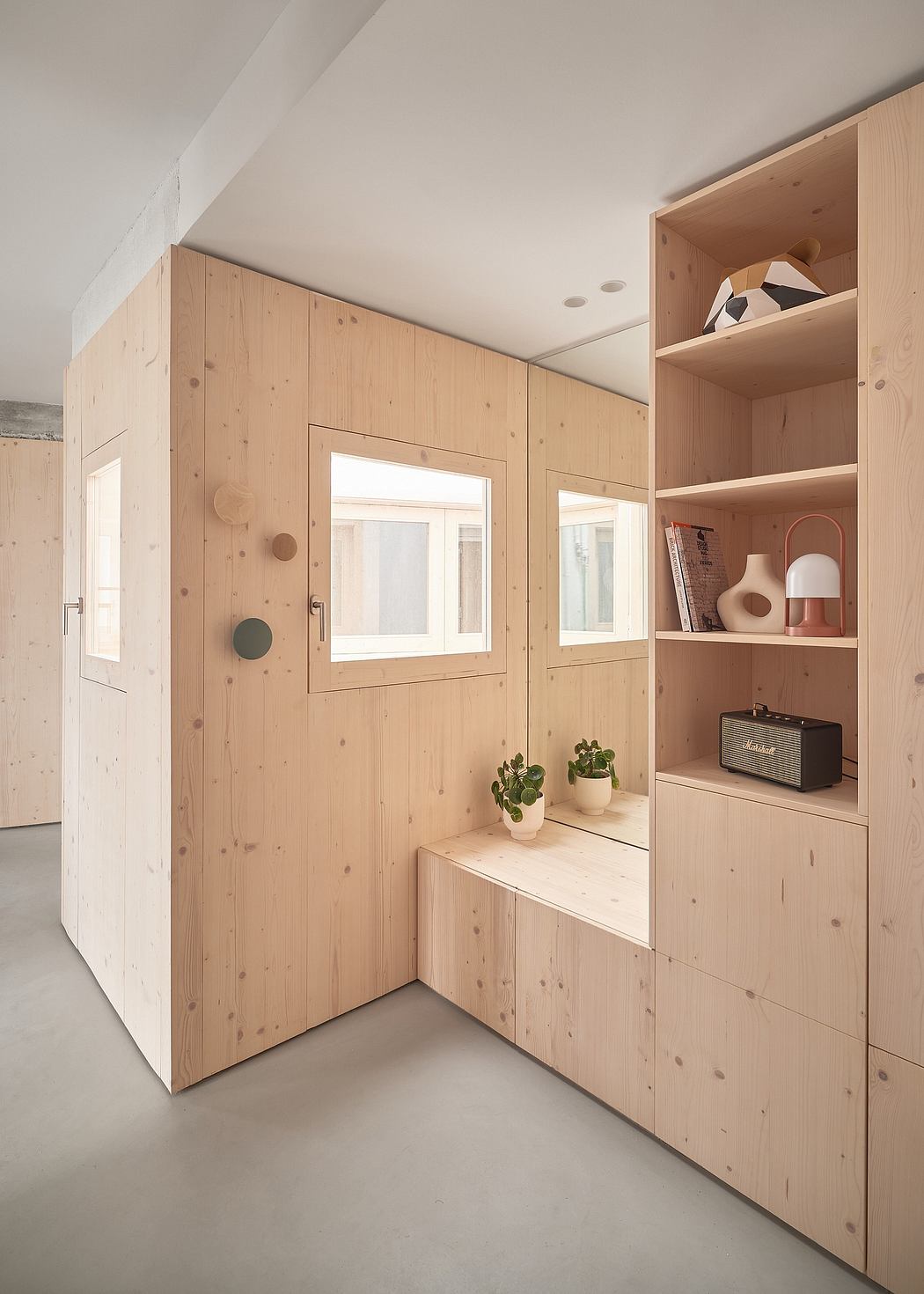 Minimalist wooden interior with built-in shelves, storage, and decorative elements.