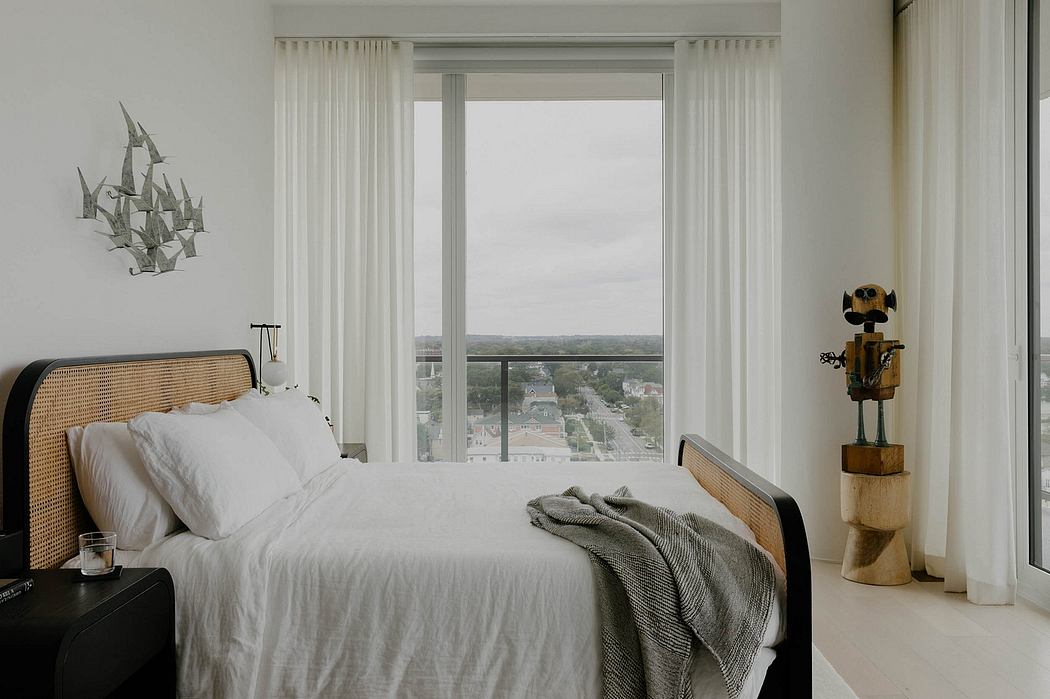 Spacious bedroom with floor-to-ceiling windows offering panoramic city views, modern decor.