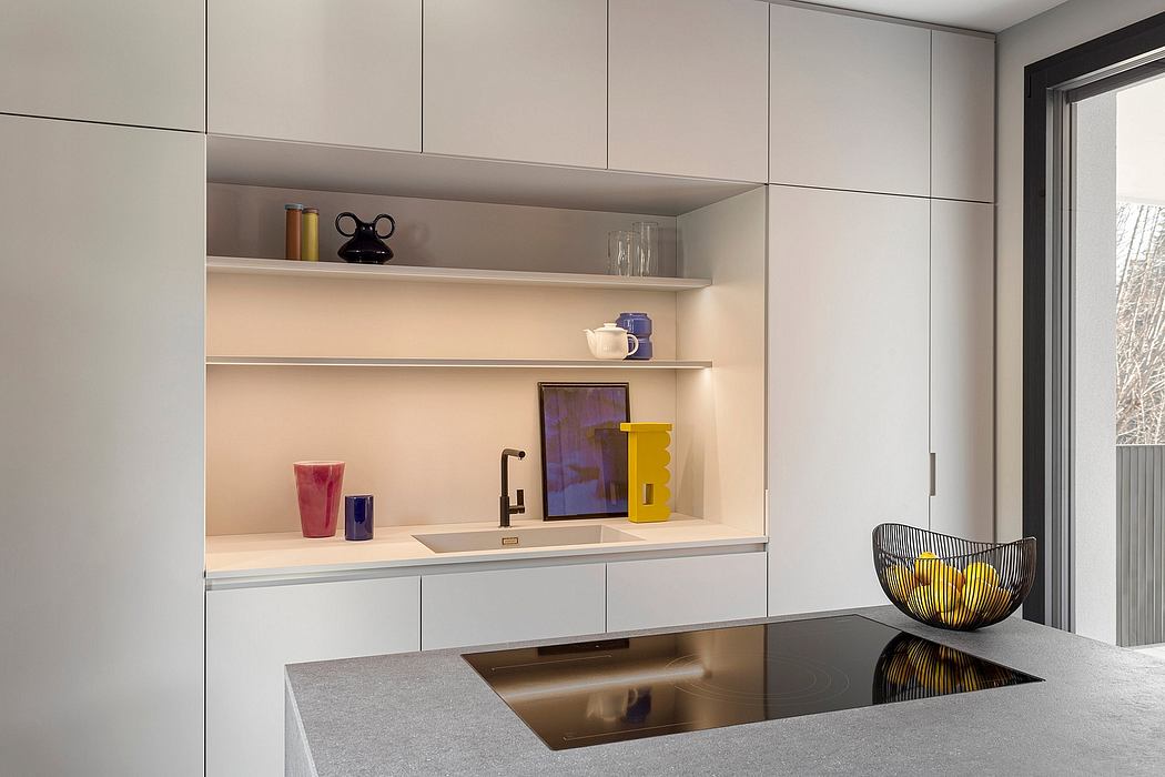 Modern kitchen with minimalist white cabinets, shelves, and built-in sink.