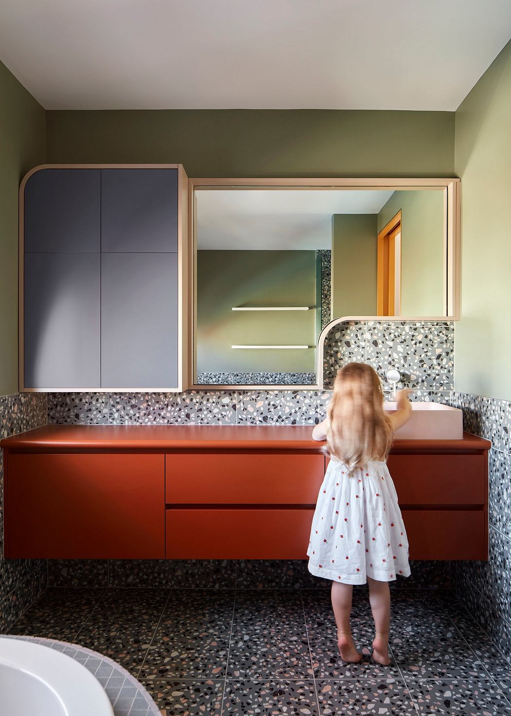Vibrant bathroom features colorful tiles, wood cabinetry, and a mirrored vanity.