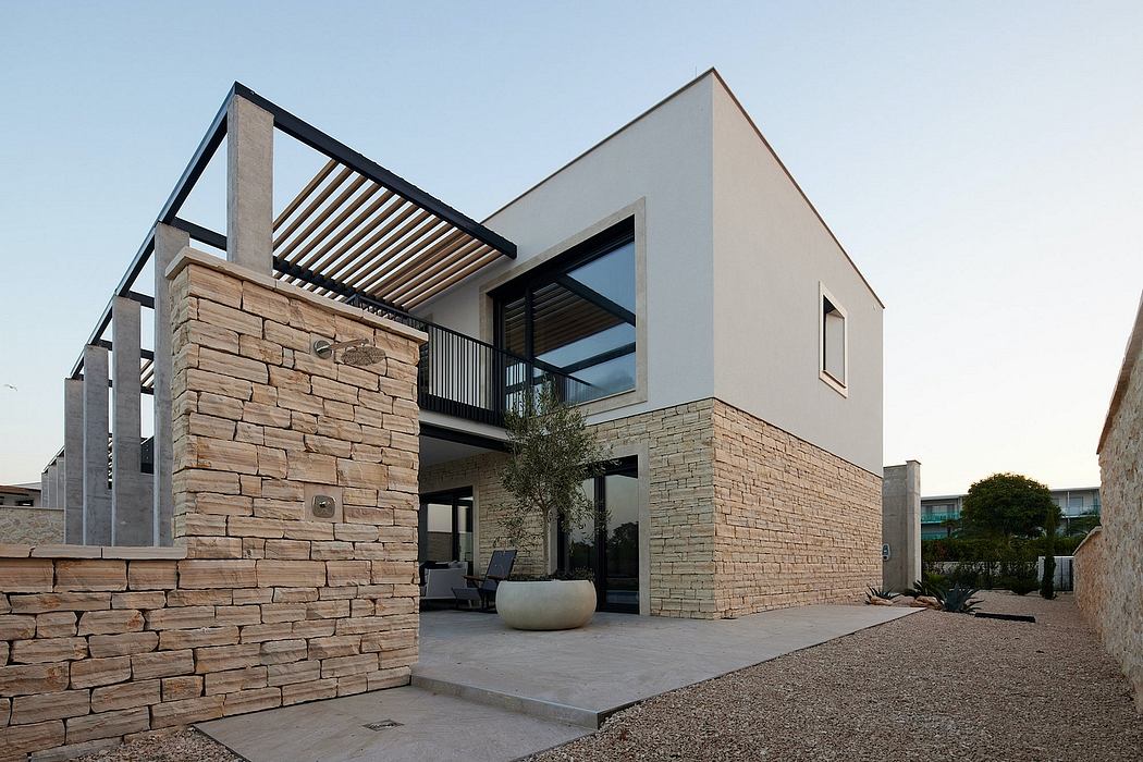 Modern, minimalist home with stone walls, sleek roof lines, and glass expanses.