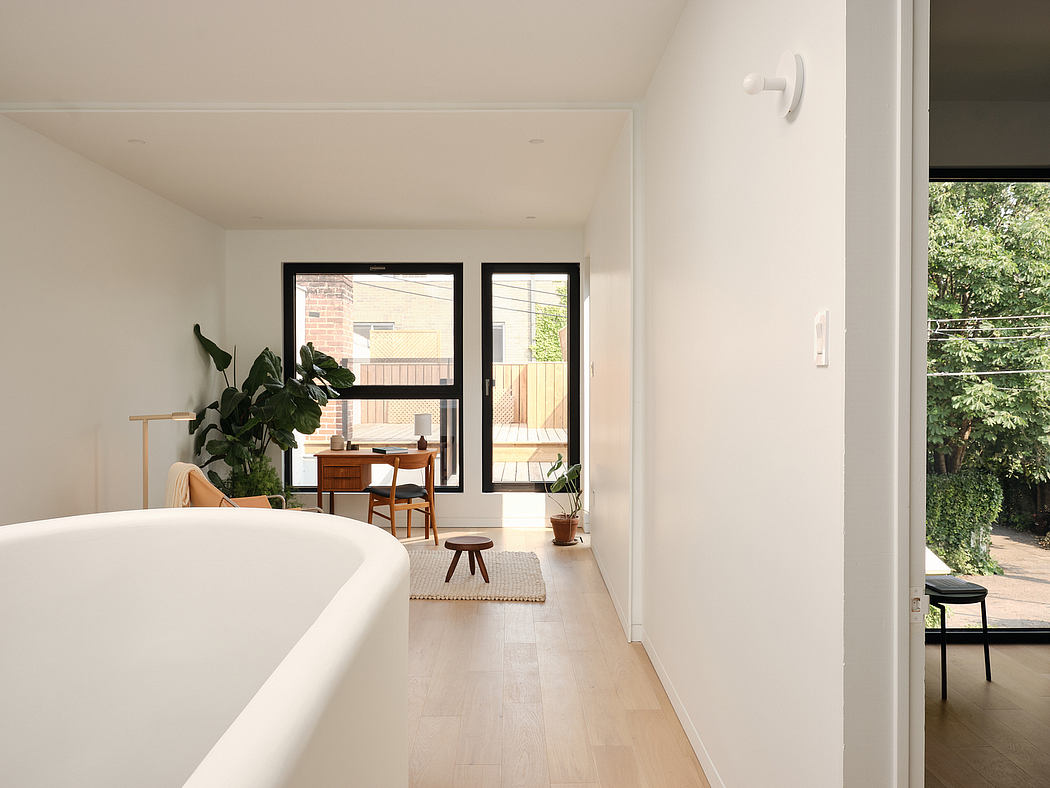 Airy, minimalist interior with white walls, large windows, and natural wood accents.