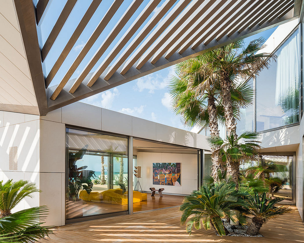 Sleek modern architecture with wood ceiling beams, palm trees, and colorful artwork.