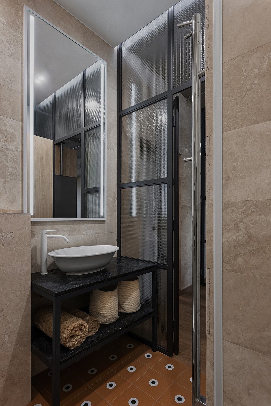 Modern bathroom with sleek black framed glass walls, a floating vanity, and patterned tile floor.