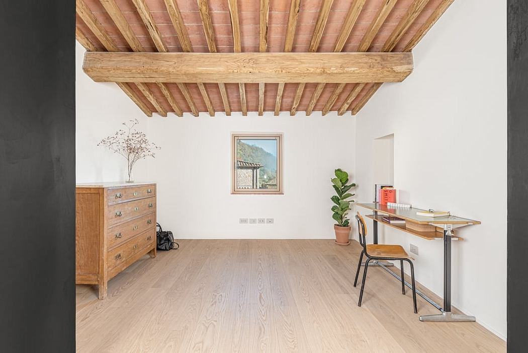 Rustic wooden beams, light hardwood flooring, minimalist furniture, framed landscape.