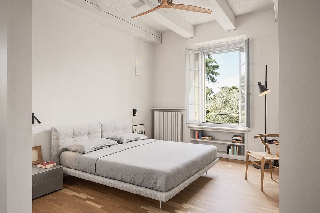 Airy bedroom with vaulted ceilings, large window, and contemporary furnishings.