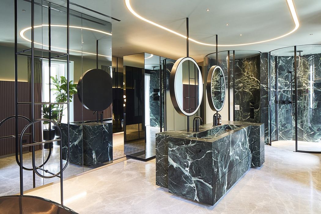 Luxurious, modern bathroom design with sleek black marble vanities, circular mirrors, and recessed lighting.