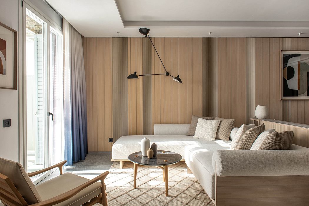 Cozy modern living room with wooden paneled walls, plush white sofa, and minimalist lighting.