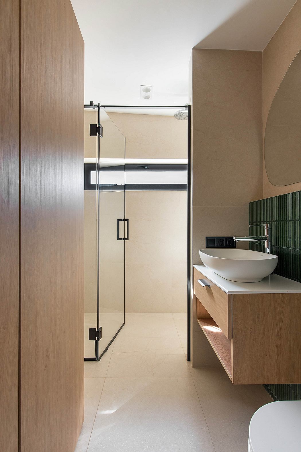 A modern bathroom with a sleek glass shower enclosure, a vessel sink, and wooden vanity.