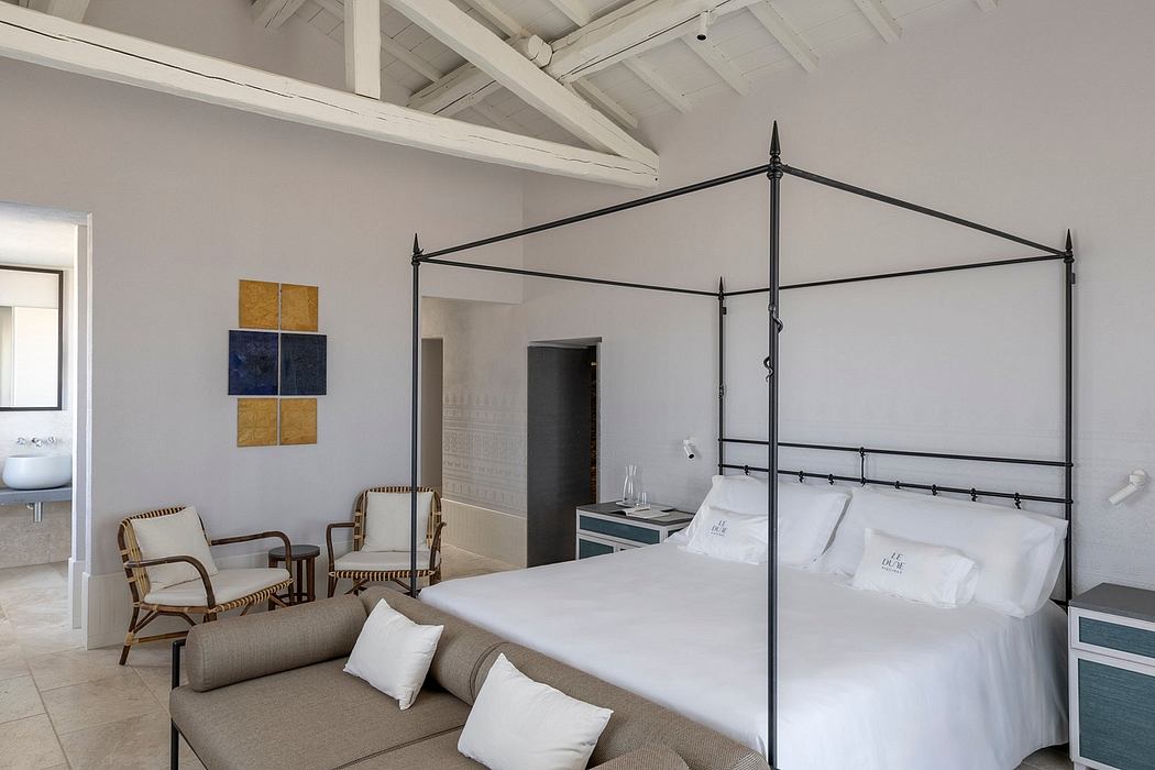 Spacious room with high ceilings, black metal four-poster bed, and stylish decor.