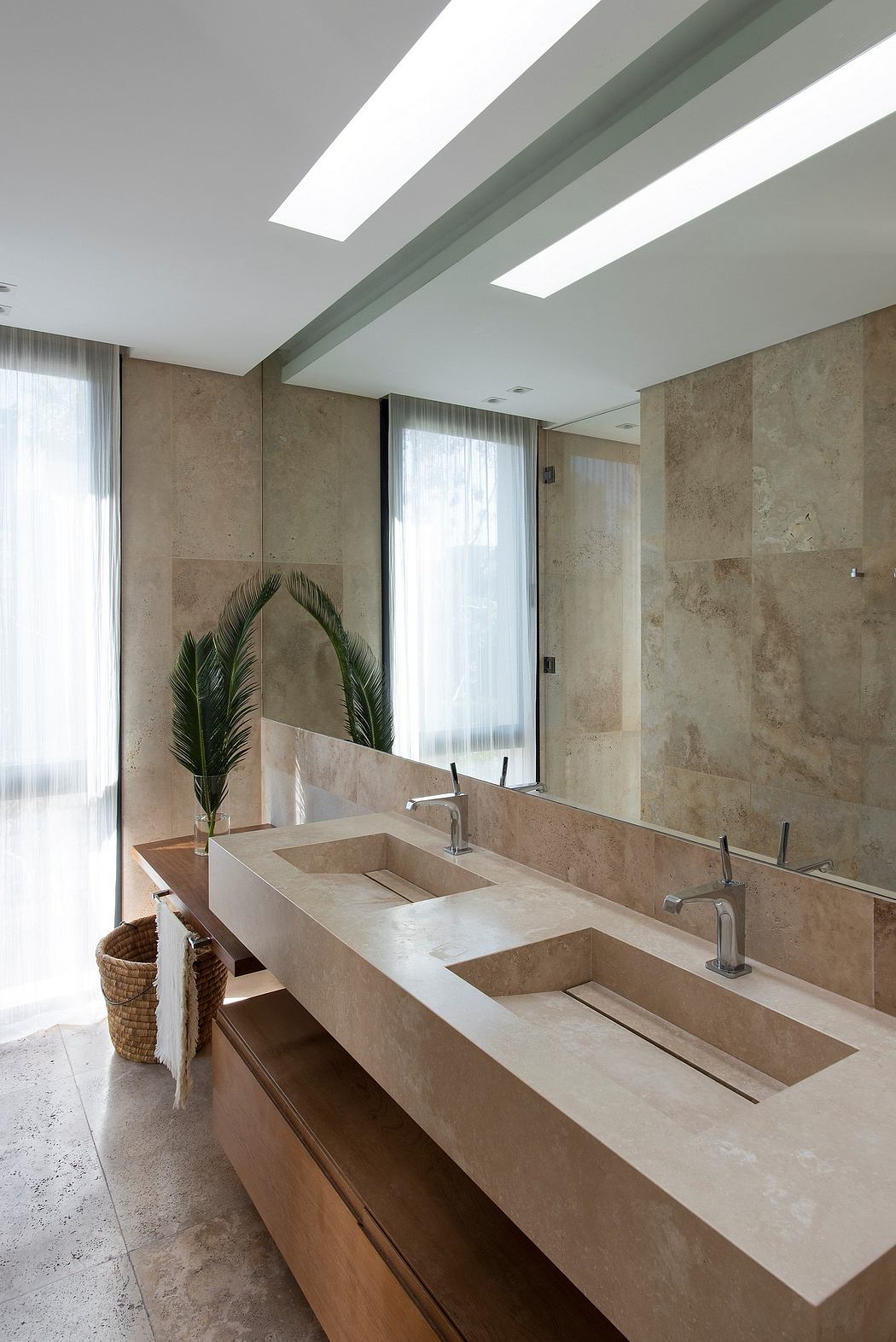 Elegant bathroom with sleek beige stone countertop, dual sinks, and modern lighting.