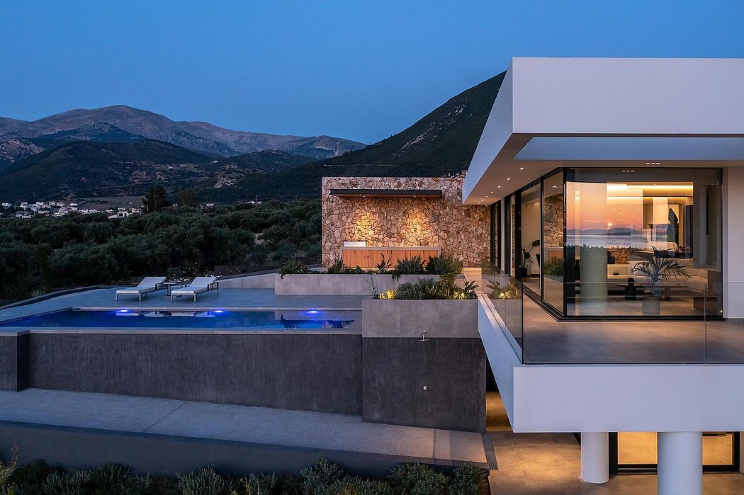 Sleek modern villa with illuminated pool, stone accents, and scenic mountain views.