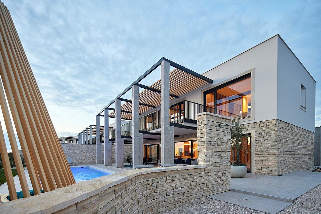 Modern, stone-clad home with sleek wooden beams, glass walls, and a swimming pool.