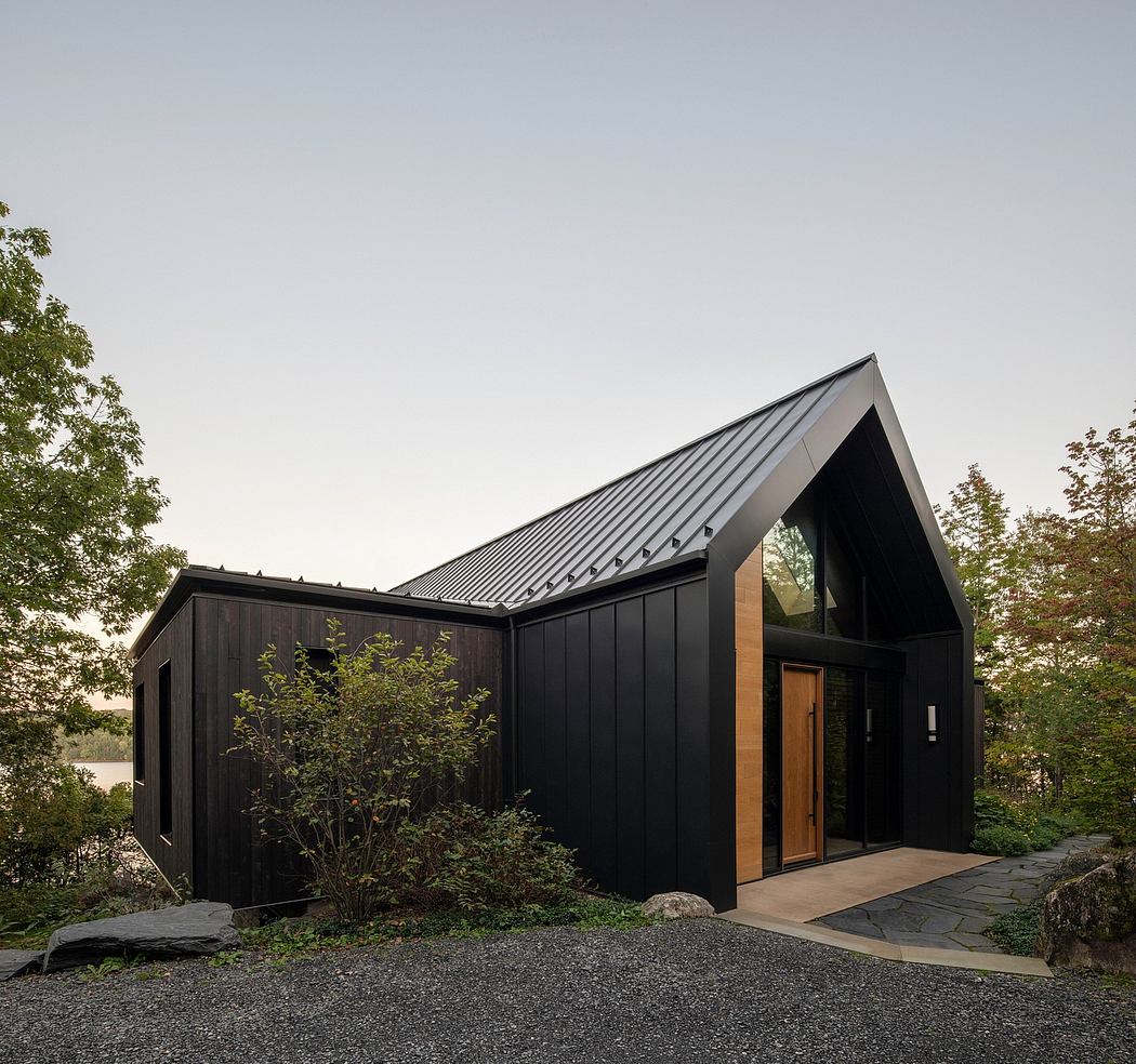 A modern, angular cabin-like structure with a slanted roof and dark exterior siding.