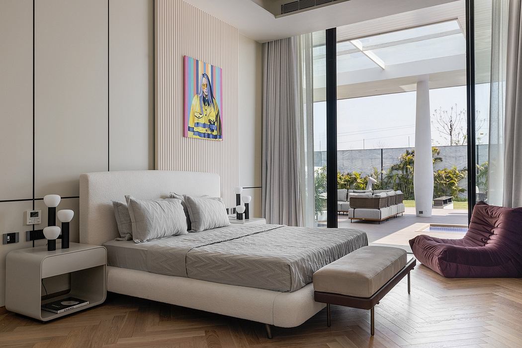 Spacious modern bedroom with minimalist furniture, artwork, and glass doors leading to outdoor garden.