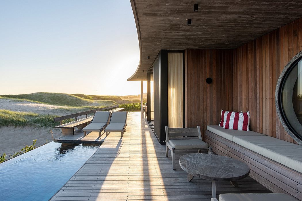 A modern, wooden vacation home with a patio, pool, and stunning ocean view.