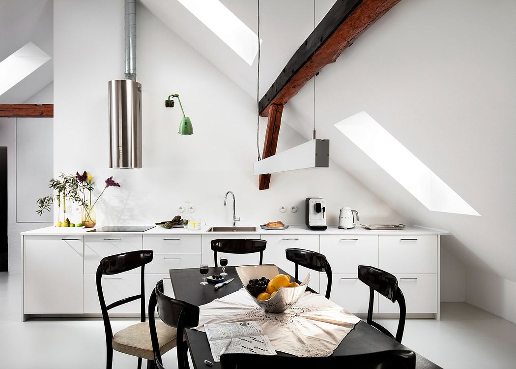 A modern kitchen with white cabinets, wooden beams, and stylish lighting fixtures.