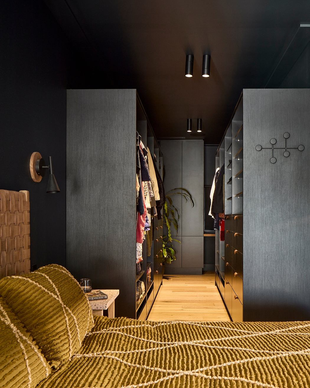 A cozy, modern hallway with minimalist, textured walls, recessed lighting, and a patterned rug.