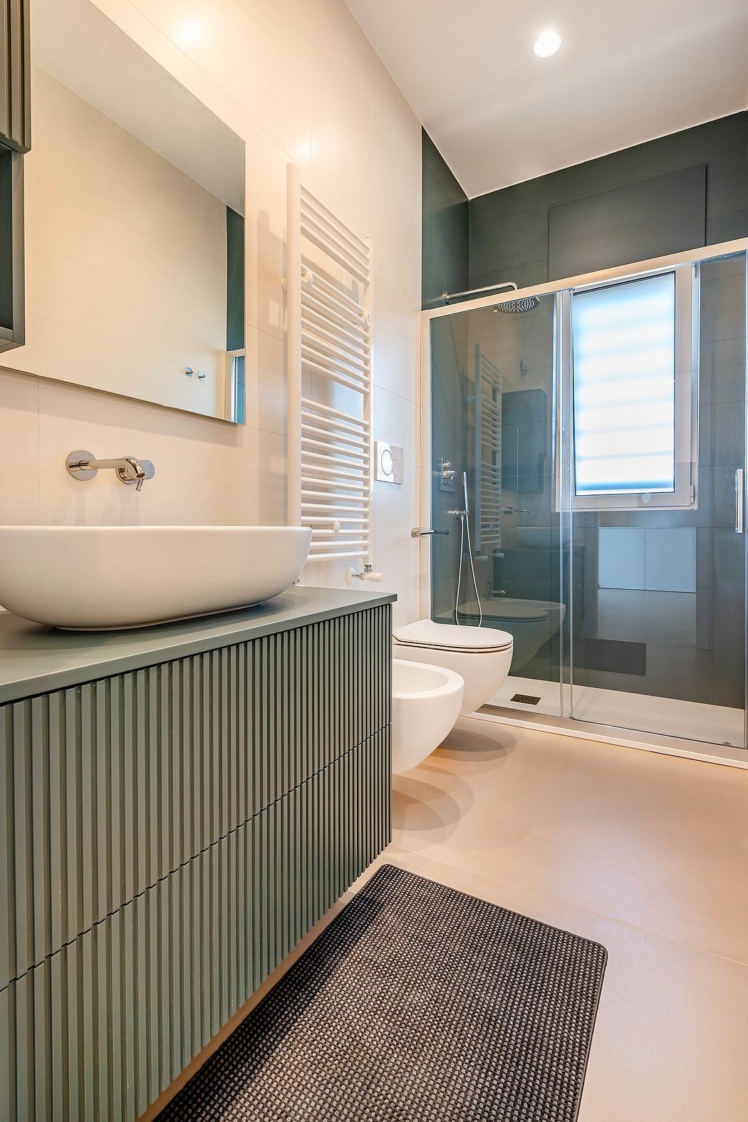 A modern bathroom with a white porcelain sink, a tiled shower, and a stylish radiator.