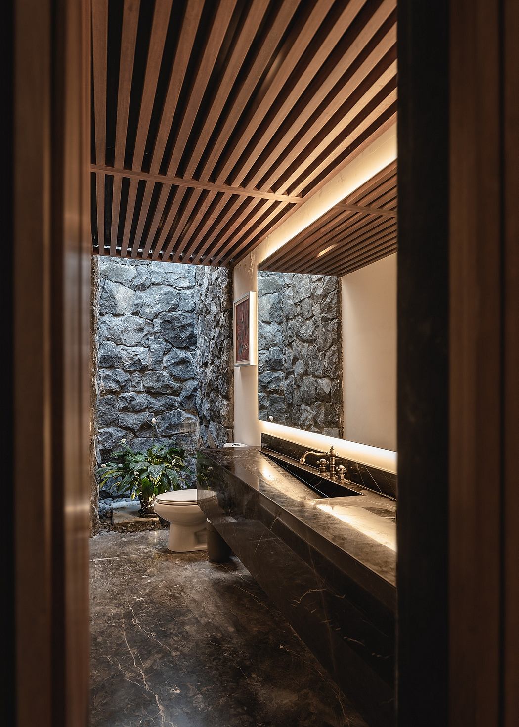 A rustic bathroom with stone walls, wood ceiling, and marble countertop vanity.